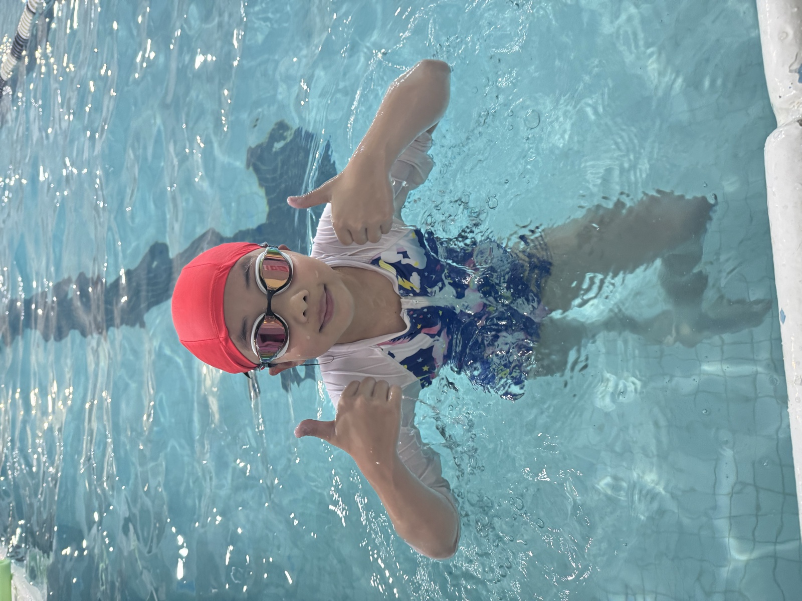 A young Shark Swim student smiling in the pool
